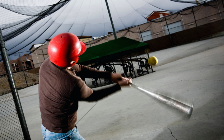 A player swinging a bat in a batting cage