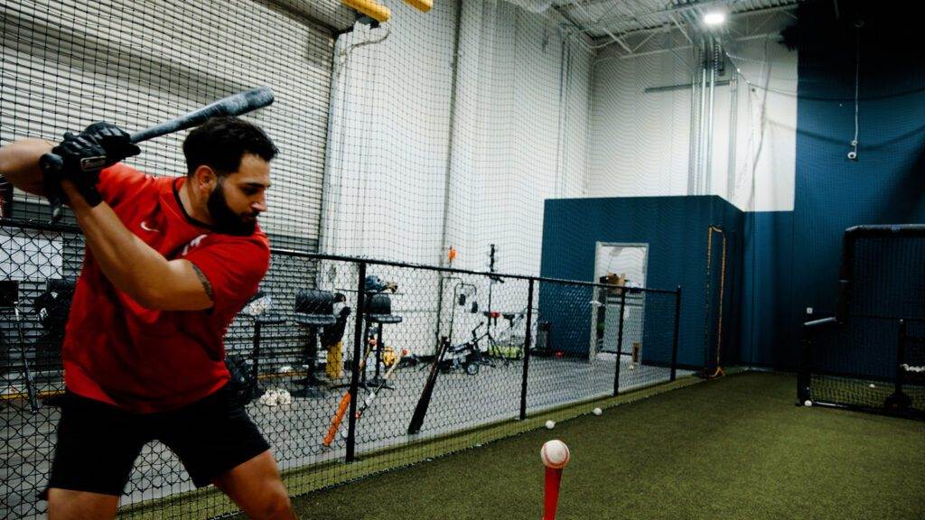 Coach Mike hitting a baseball from a tee