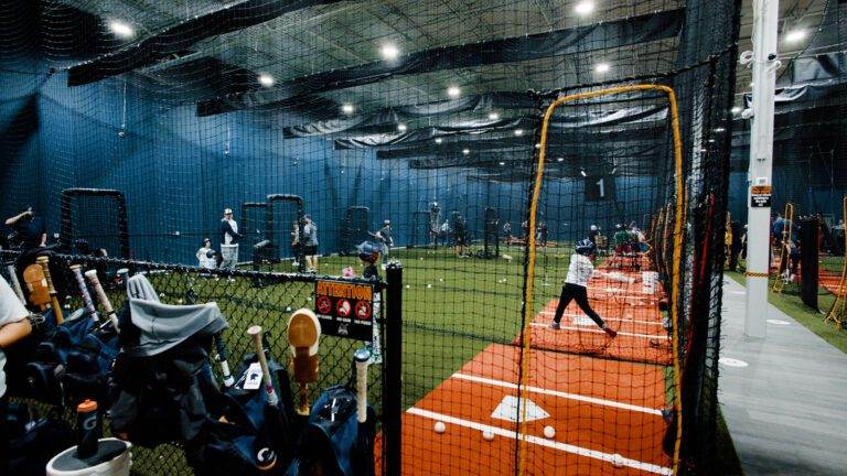 Players are batting inside the batting cages.
