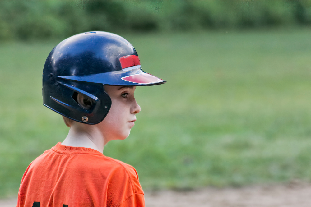 A youth baseball player looking at the field